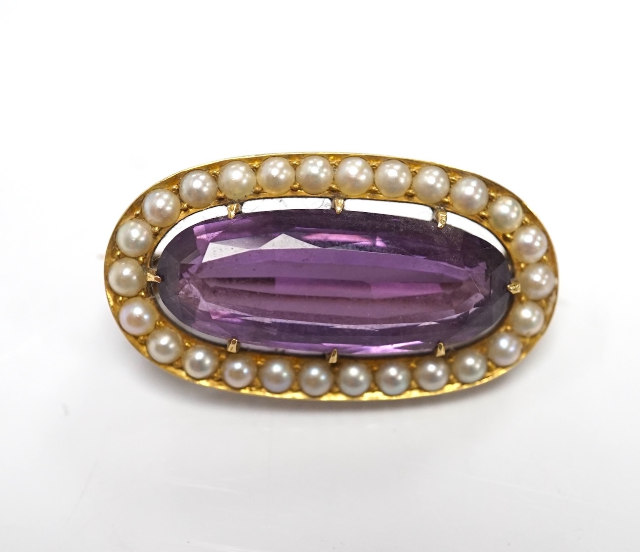 An early 20th century yellow metal mounted amethyst and split pearl cluster set oval brooch, 32mm, gross weight 8.8 grams. Condition - fair to good